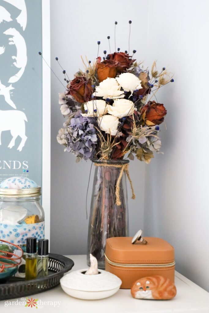 dried flower bouquet sitting on top of a dresser as apartment decor