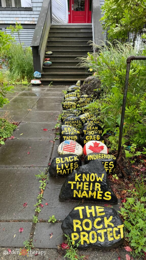 Painted stones at entrance reading, "The rock project" "Know their names" and "Black lives matter"