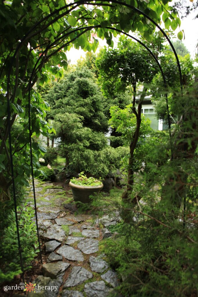green backyard with arch and paving stones