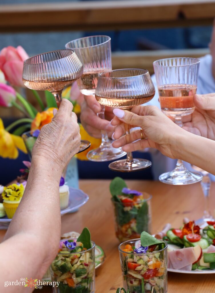 cocktails being cheered over table of food at garden party