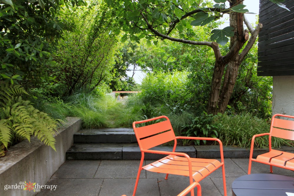 orange chairs on patio next to stone stairs