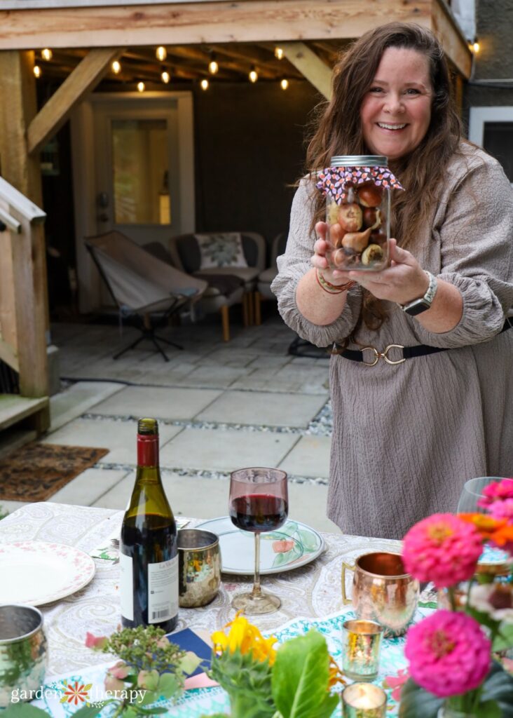 a smiling Stephanie holding jar of bulbs