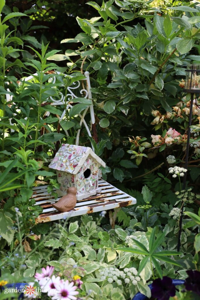 birdhouse sitting on old chair in garden