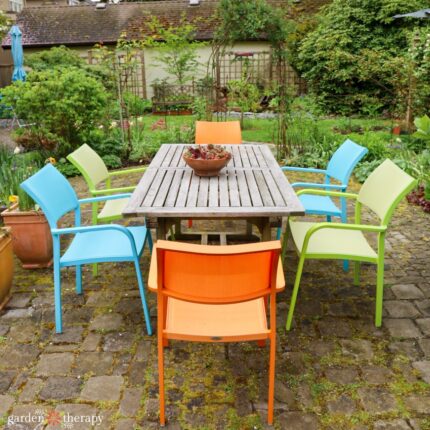 Colourful patio chairs around outdoor dining table