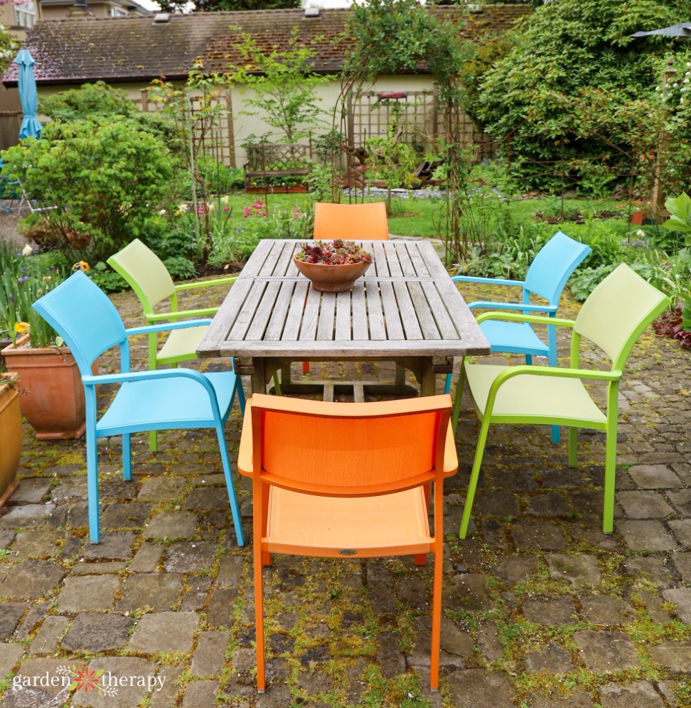 Colourful patio chairs around outdoor dining table
