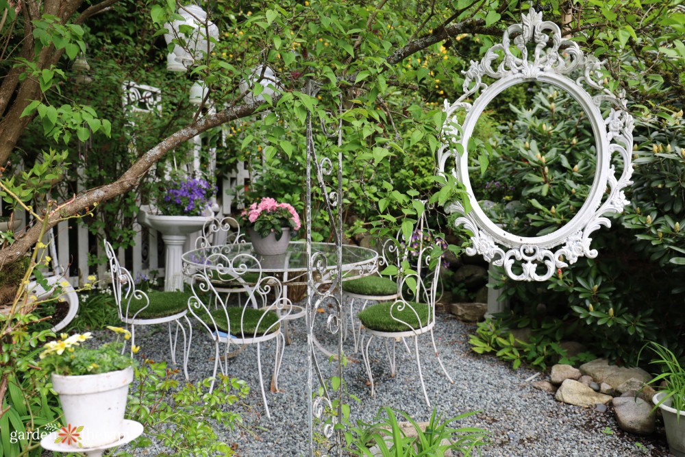 wrought iron patio set with empty frame hanging from tree