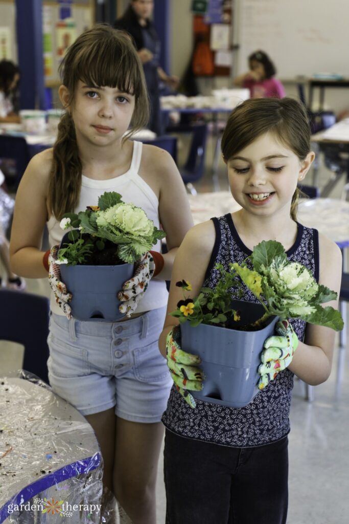 two young girls smiling and holding their bee breakfast pots
