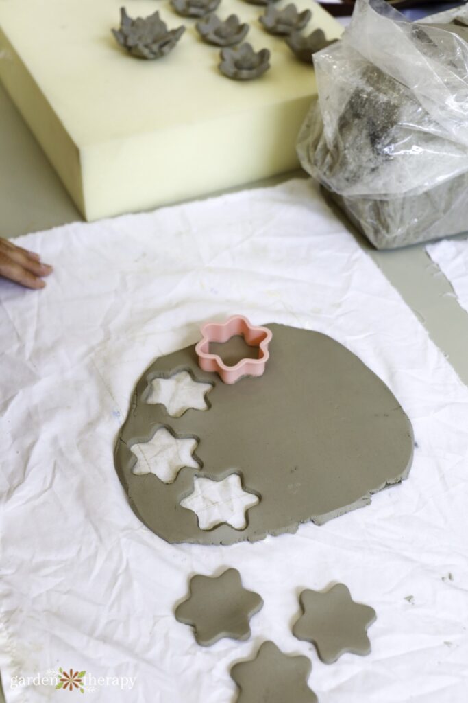 using flower cookie cutter on rolled out clay