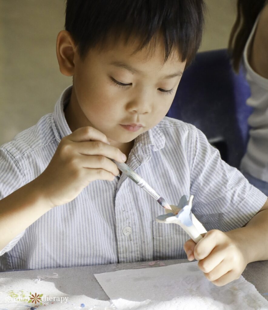 boy painting bee cup