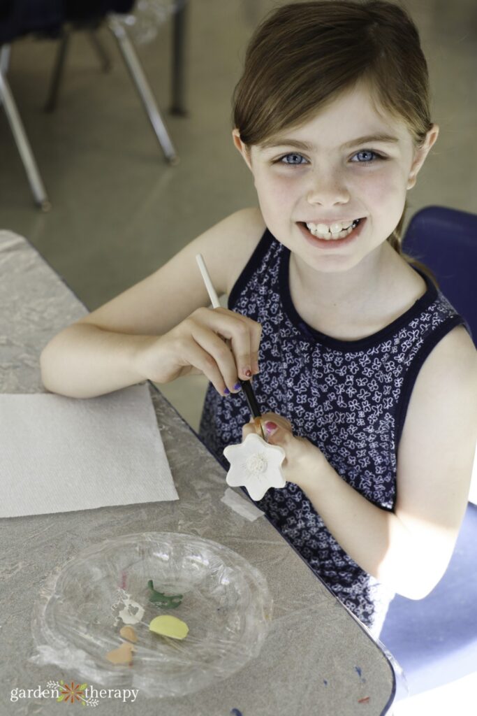 girl painting bee cup