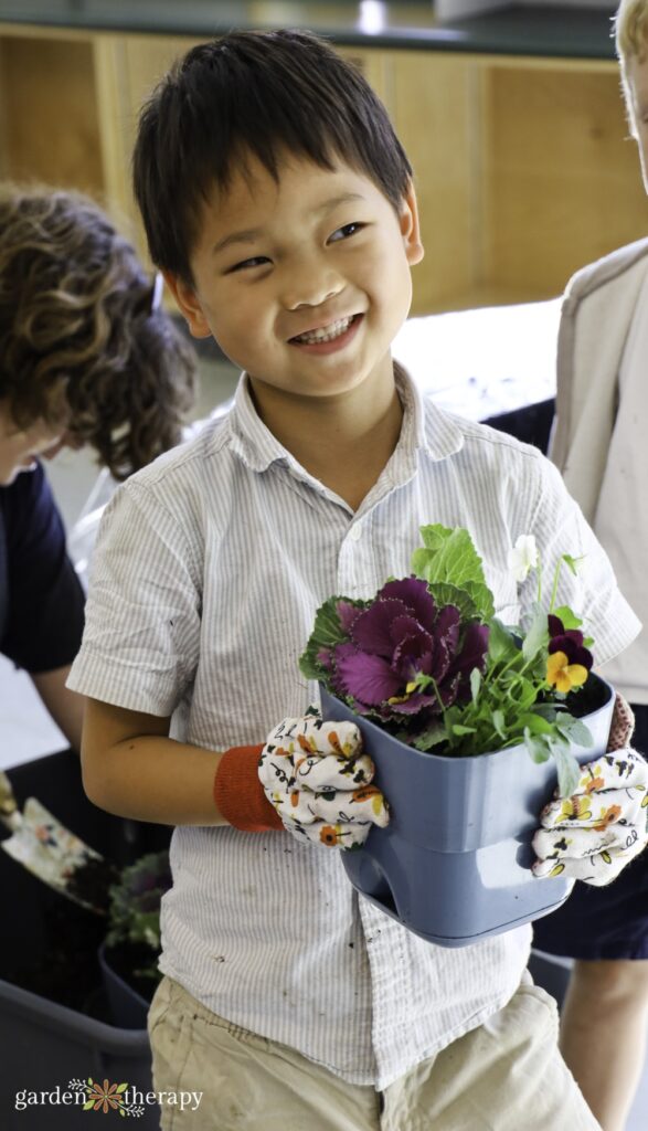 young boy smiling holding his bee breakfast planter