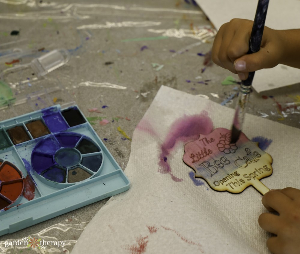 painting wooden signs to welcome bees